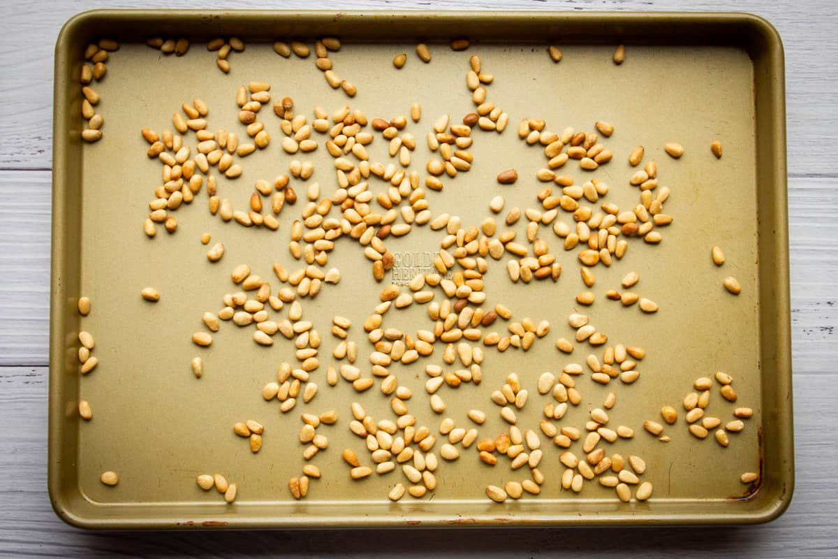 Toasting the pine nuts on a tray in the oven.