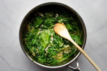 The cooked spinach in the pan.