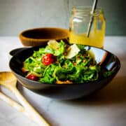 Rocket salad on the table with sunflower dressing in the background.