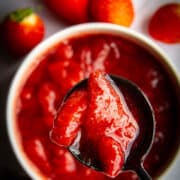 Strawberry sauce in a pot with a spoon.