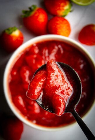Strawberry sauce in a pot with a spoon.