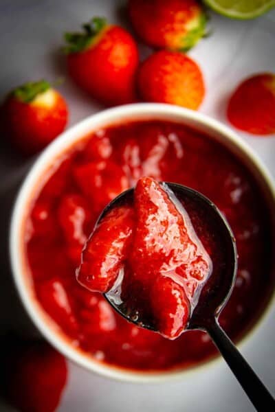 Strawberry sauce in a pot with a spoon.