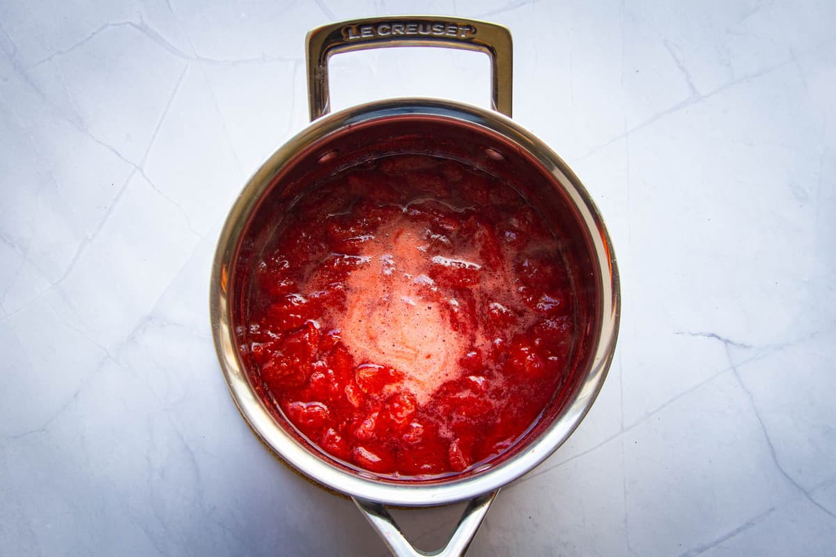 The strawberry sauce cooking in the pan.