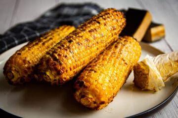 The smoked and grilled corn on a plate with umami butter on the side.