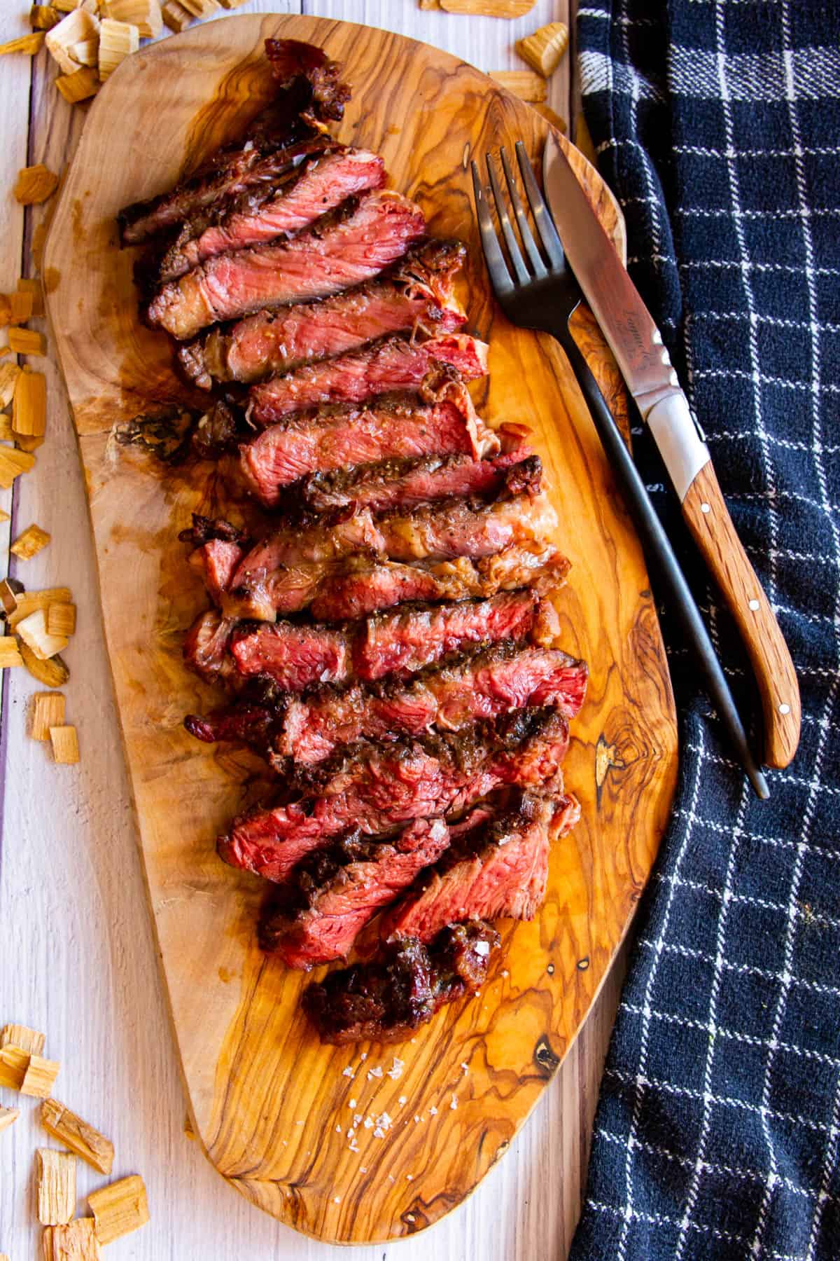 Smoked ribeye sliced on a wooden board.