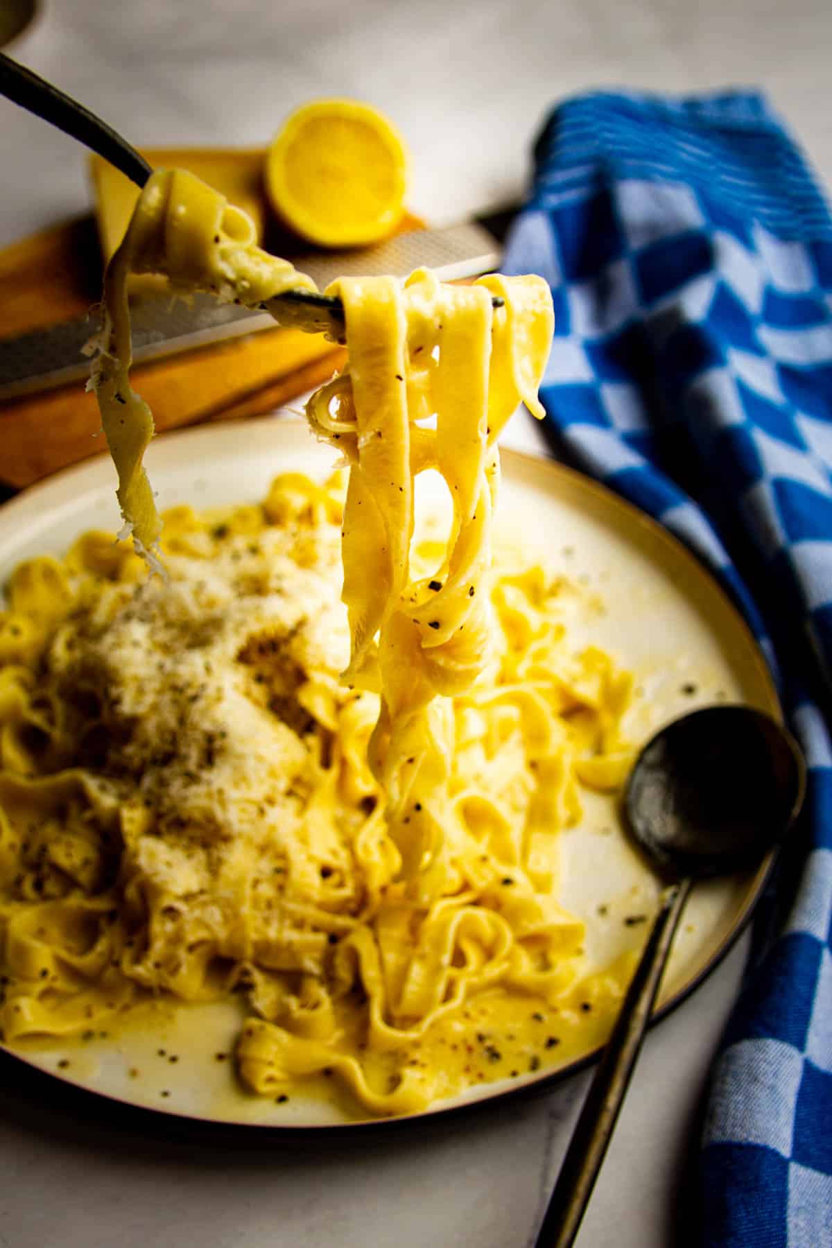 Cacio e pepe pasta being lifted up with a fork.