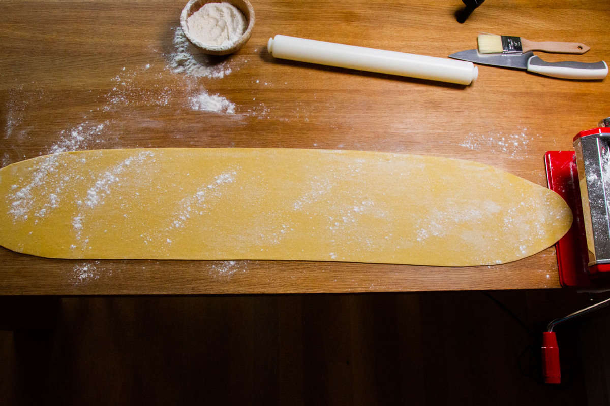 Rolling out the dough on the pasta machine.