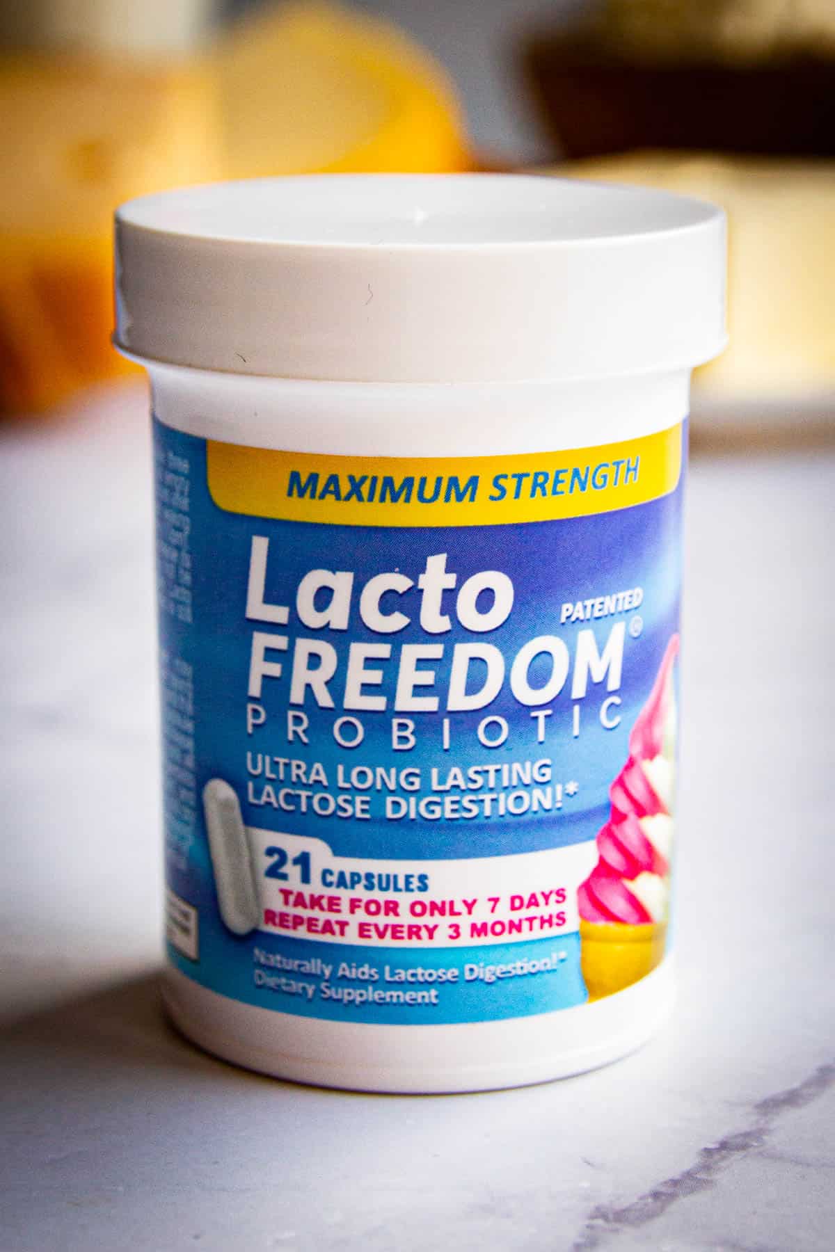 A bottle of Lacto Freedom supplements with milk products in the background.