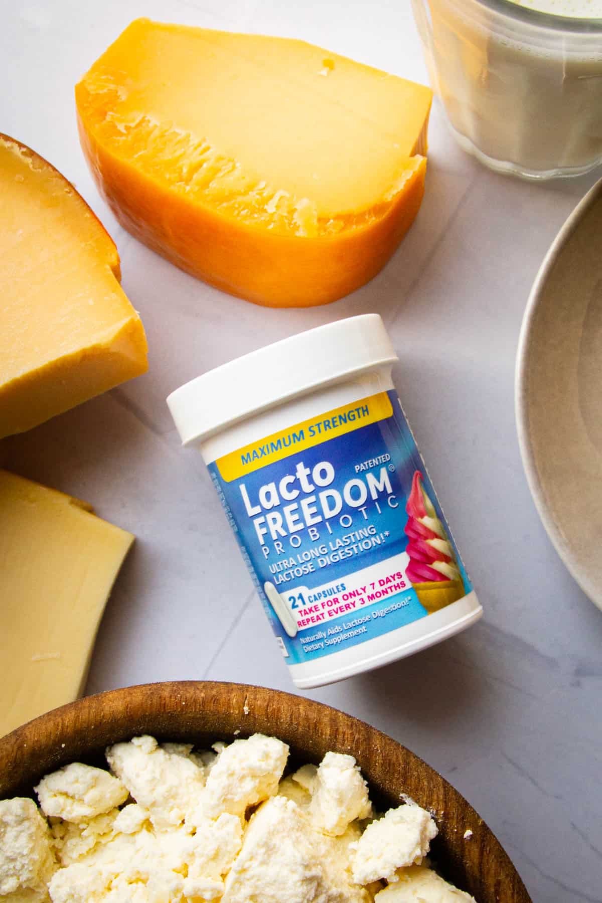 A bottle of Lacto Freedom supplements with milk products in the background.