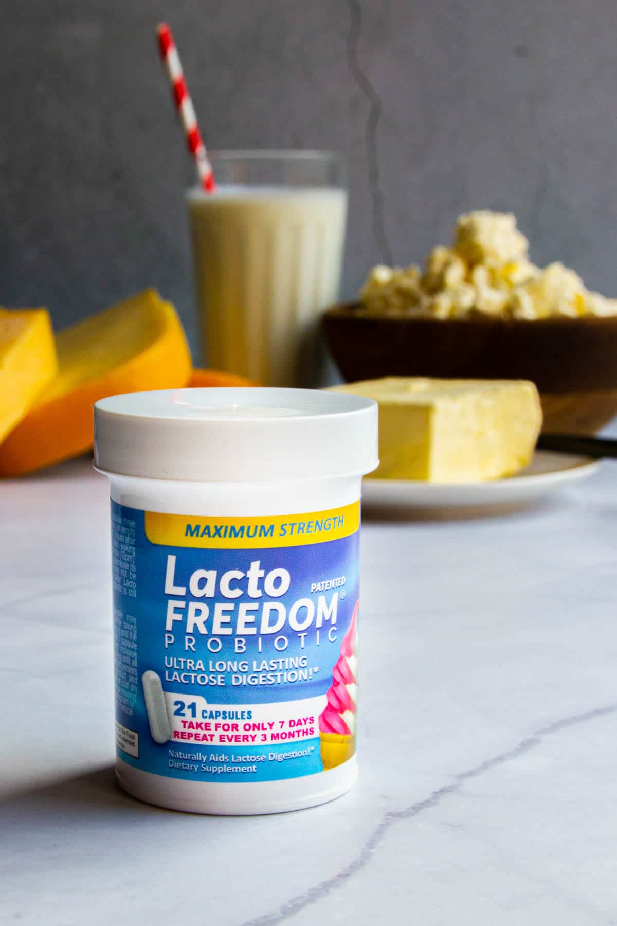 A bottle of Lacto Freedom supplements with milk products in the background.