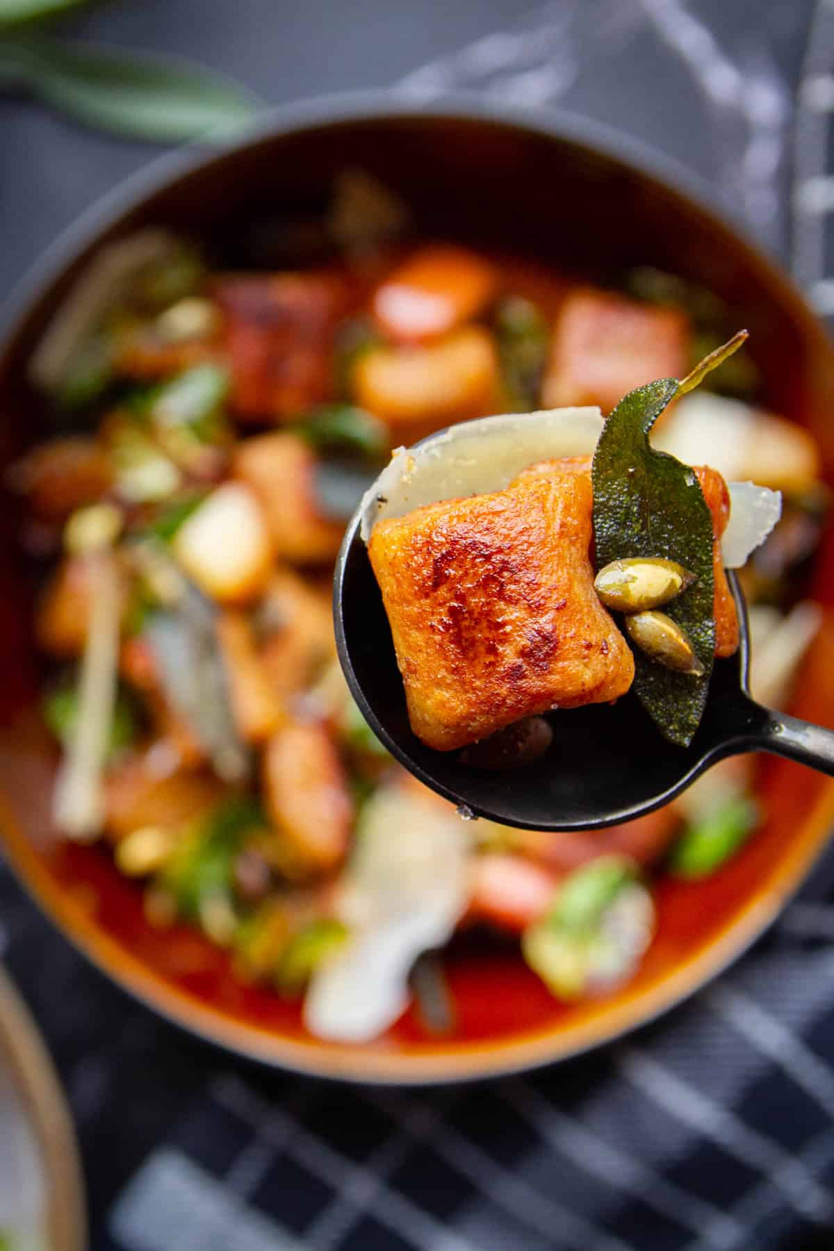 Pan fried brown butter ricotta gnocchi on a spoon.