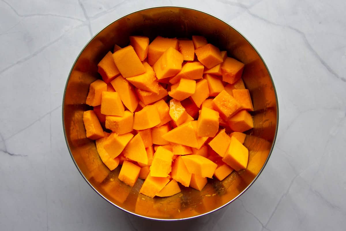 Mixing the squash in a bowl with oil and salt.
