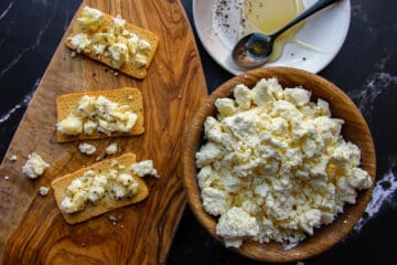 Ricotta on melba toast with honey and black pepper.