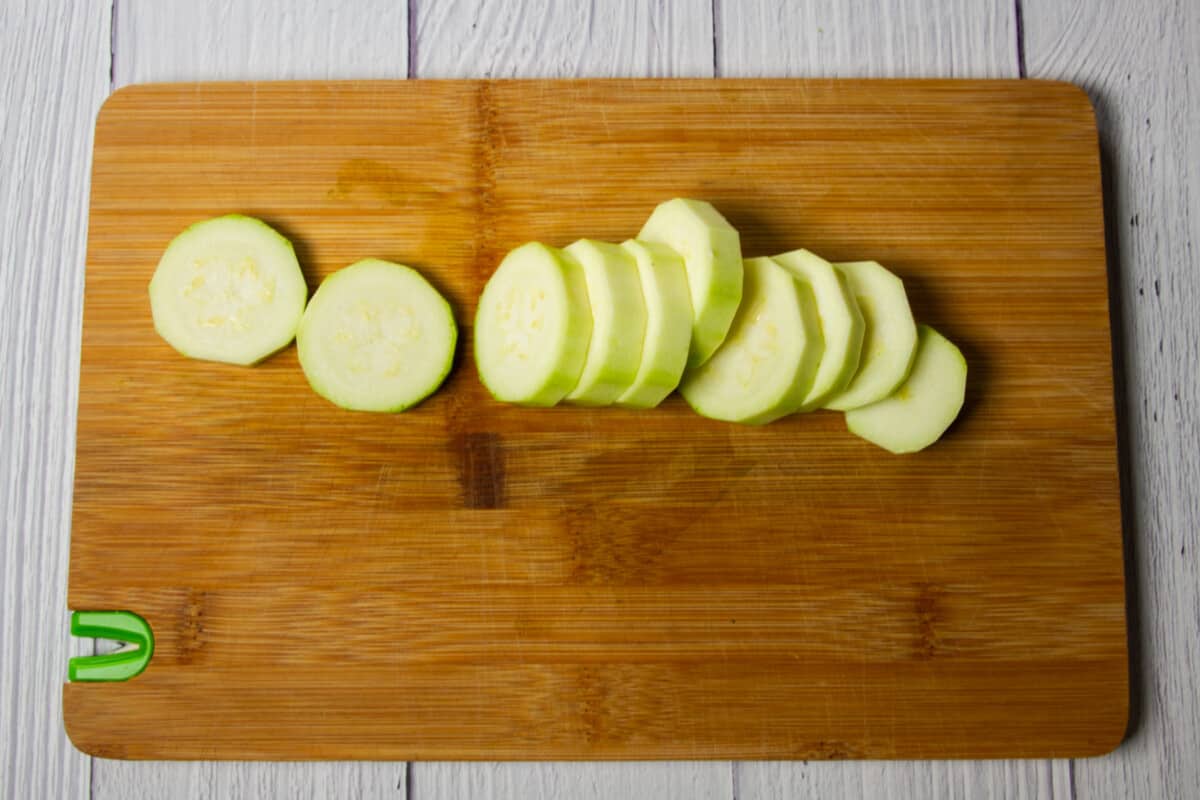 Sliced and peeled zucchini on a cutting board.
