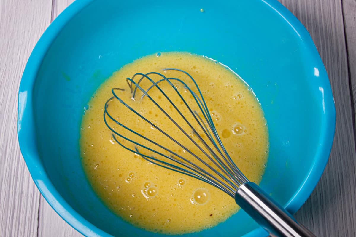 Whisking the wet ingredients together in a bowl.
