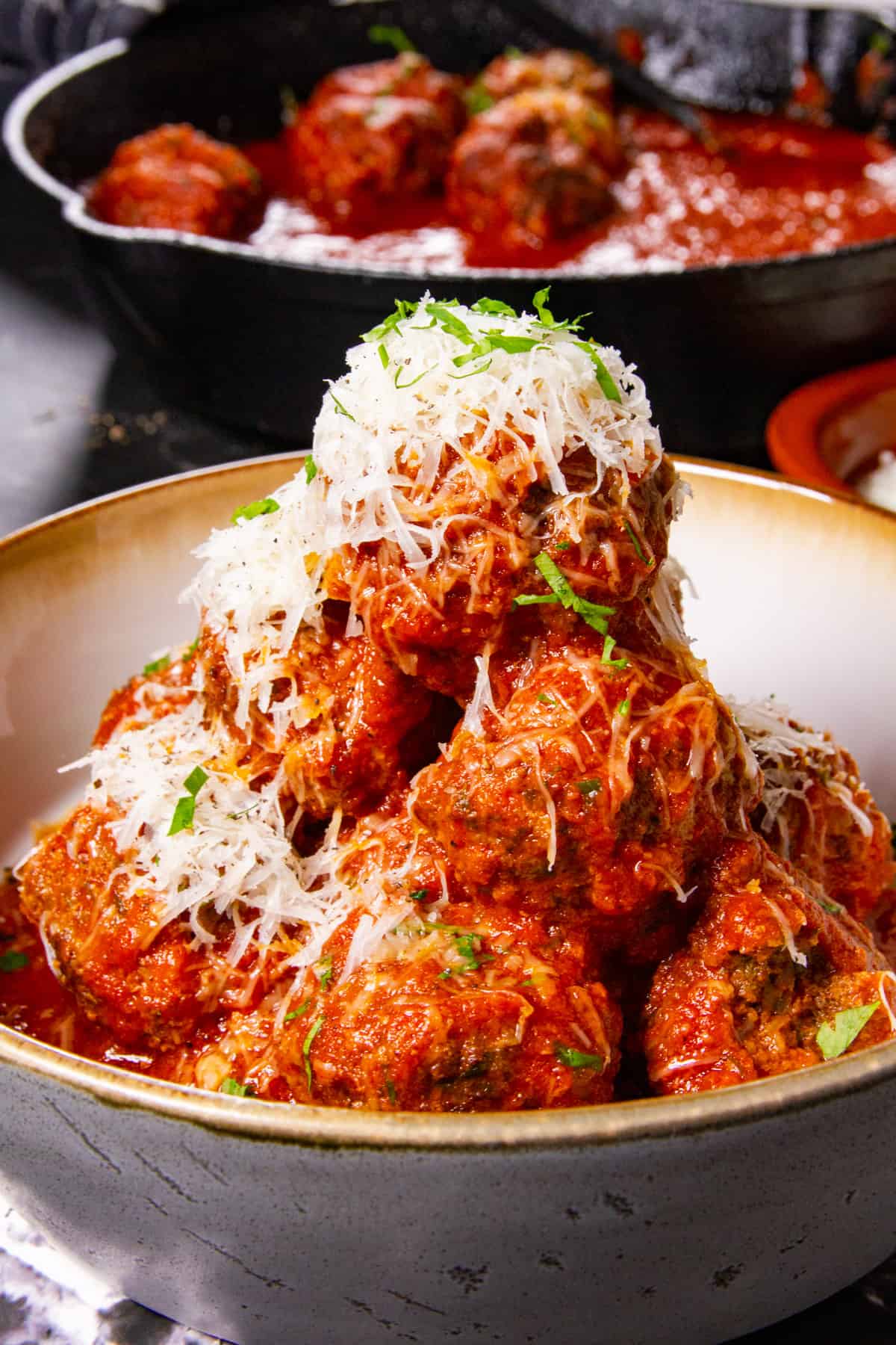 A close up of the meatballs on a plate, stacked high.