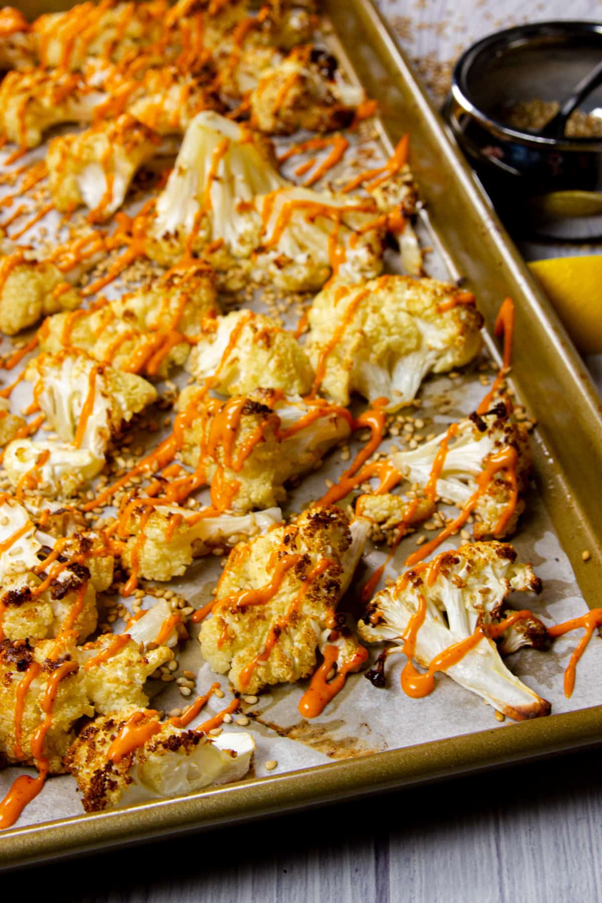 Roasted cauliflower florets on a sheet tray.