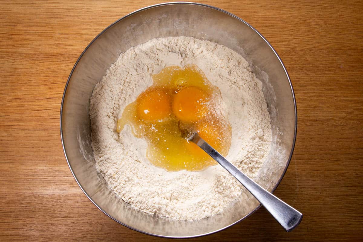 The eggs in a well in the middle of the flour.