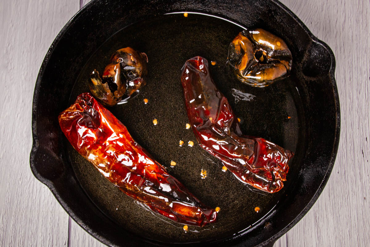 Toasting the dried cascabel and guajillo chillies in a cast iron pan.