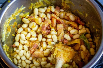 Adding the spices and beans to the soup.