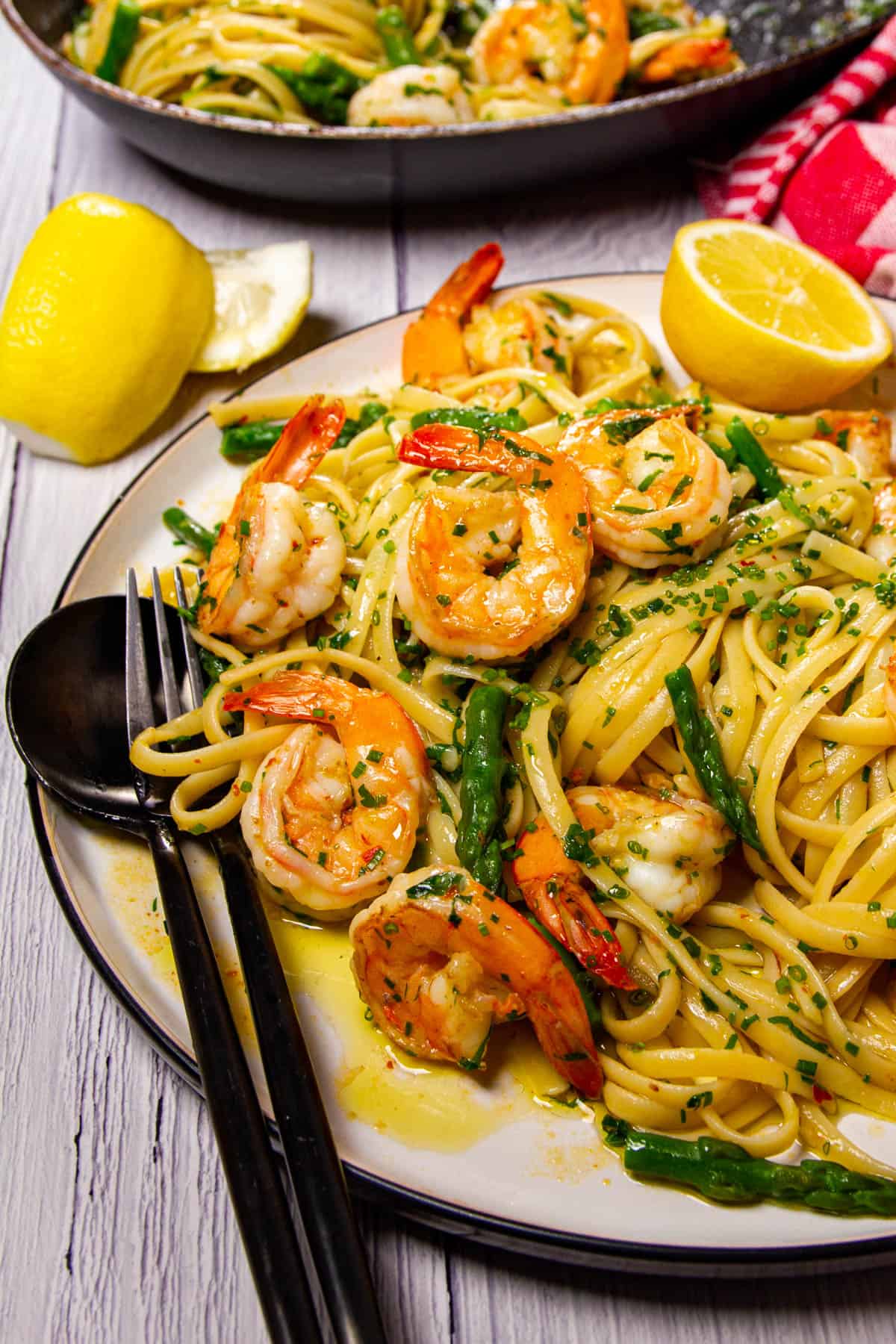 Garlic butter shrimp on a plate with lemon in the background.