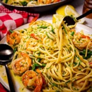 A fork inside a big plate of garlic shrimp pasta.