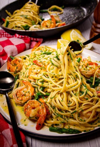 A fork inside a big plate of garlic shrimp pasta.