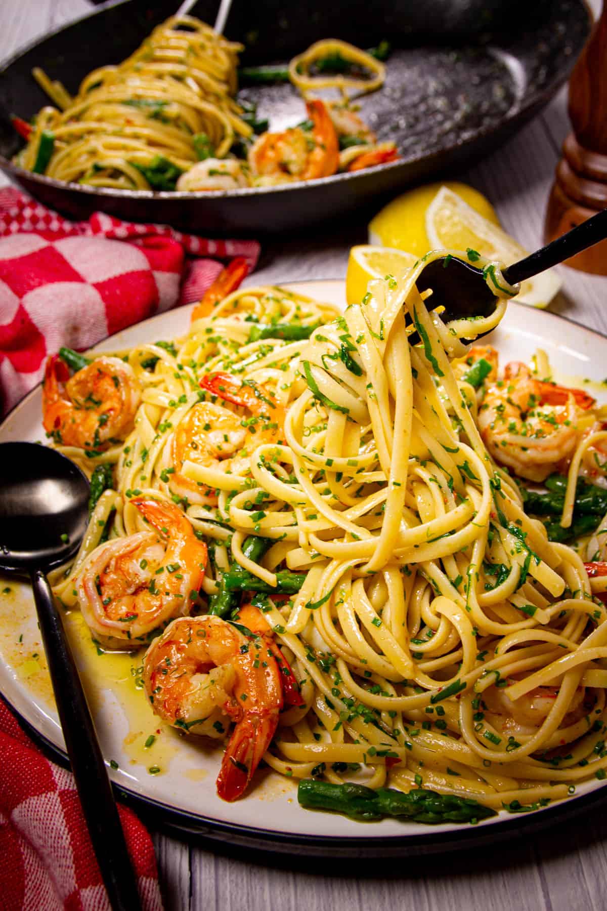 A fork inside a big plate of garlic shrimp pasta.