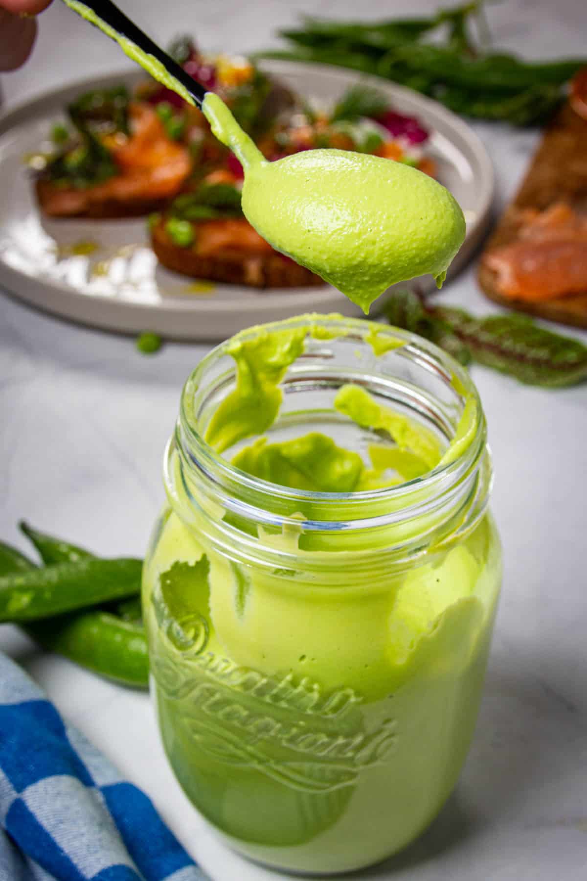 A spoon of the puree lifted out of the air with toast in the background.