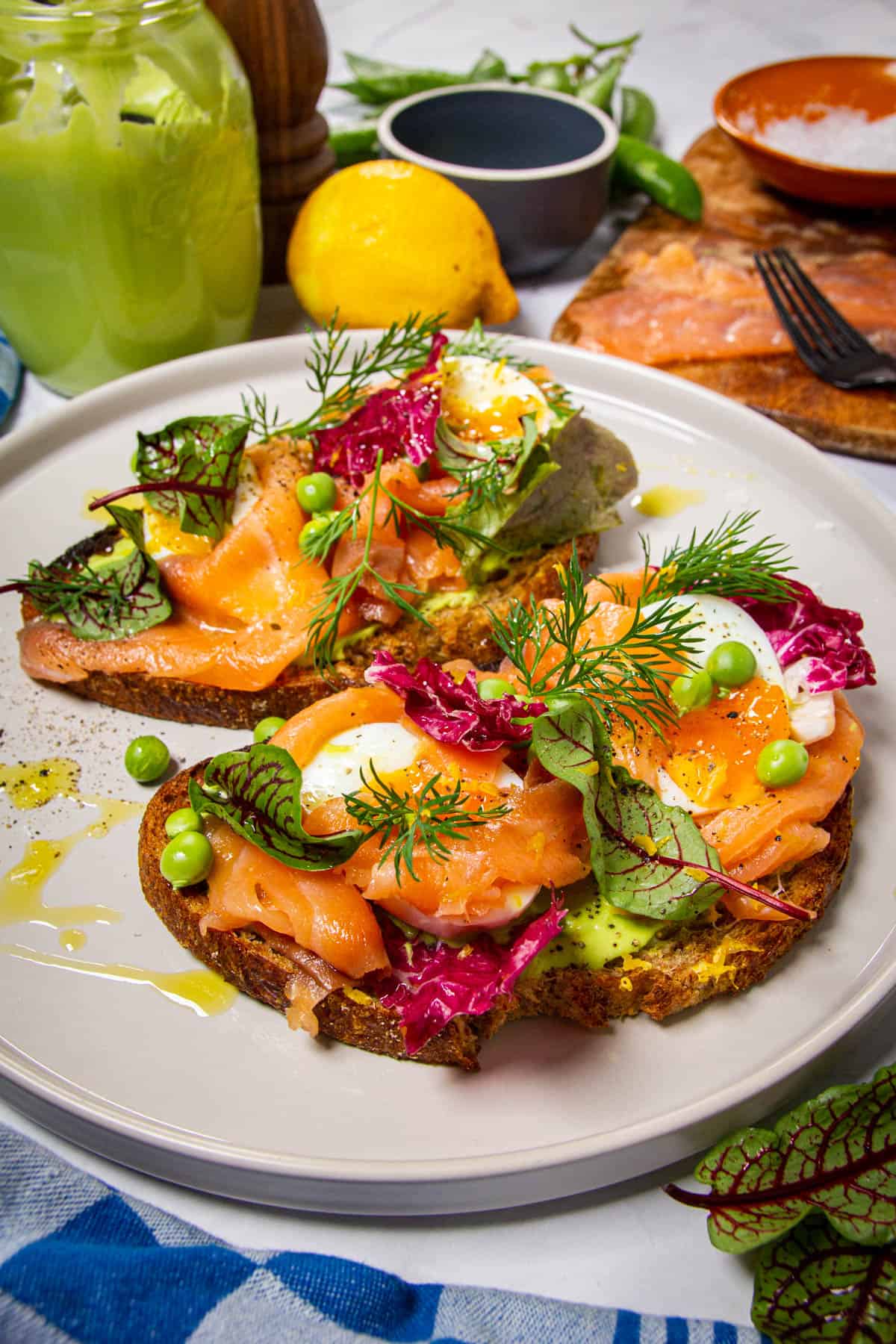 A close up shot of the smoked salmon toast with pea puree in the background.