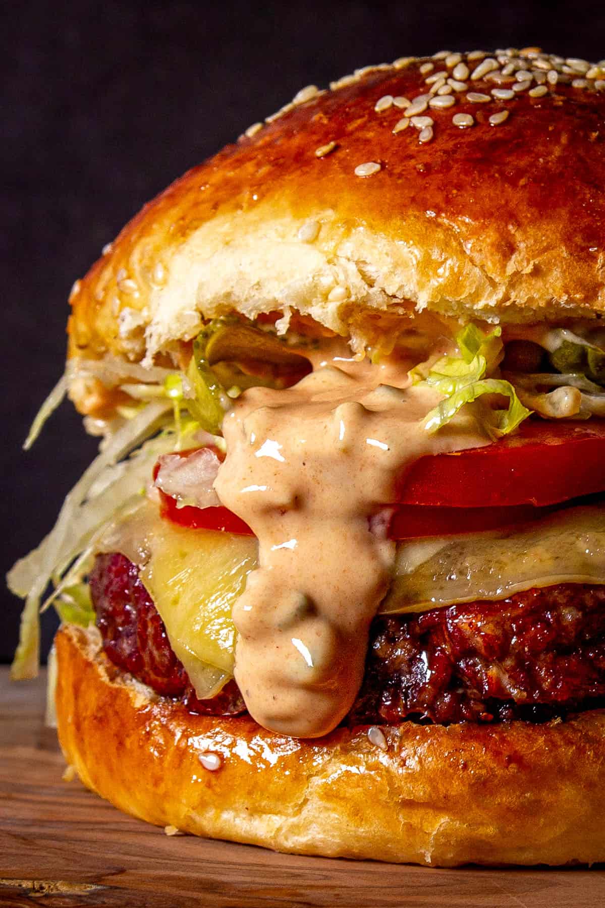 A close up shot of the smoked burger with mac sauce dripping down.