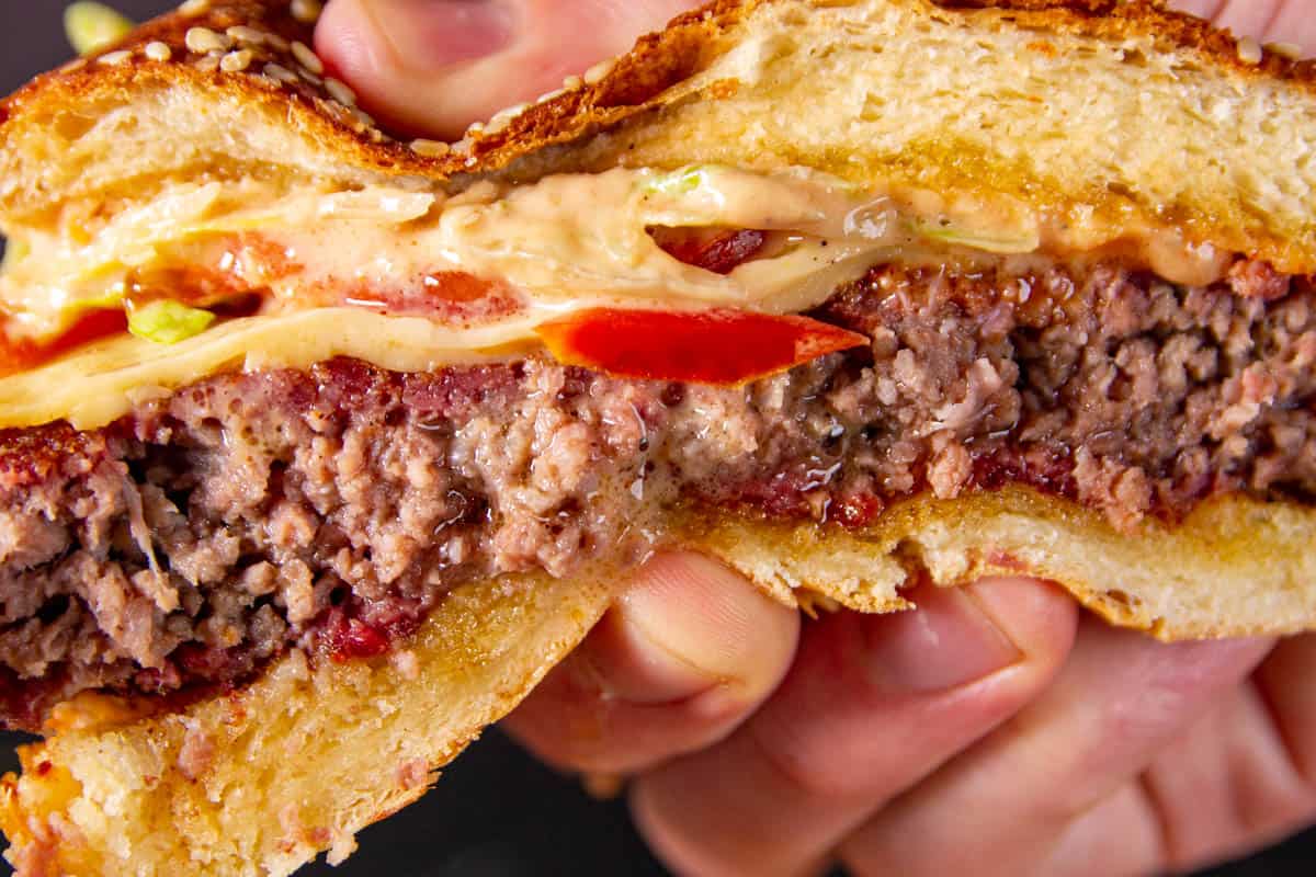 A squeeze of the burger, showing how juicy it is.