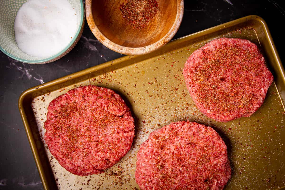 Seasoning the burgers with the spice mix and salt.