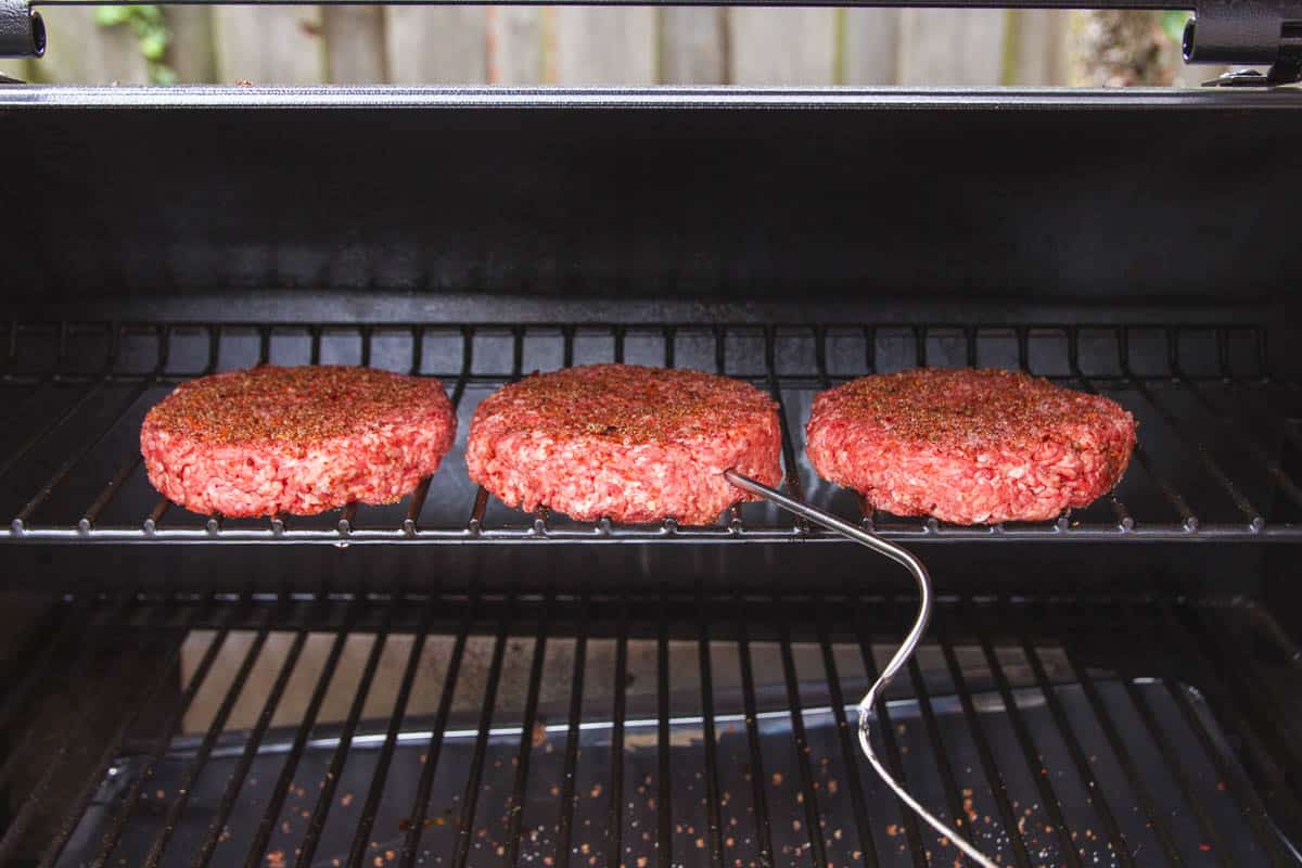 The burgers on the top rack with the temperature probe inside.