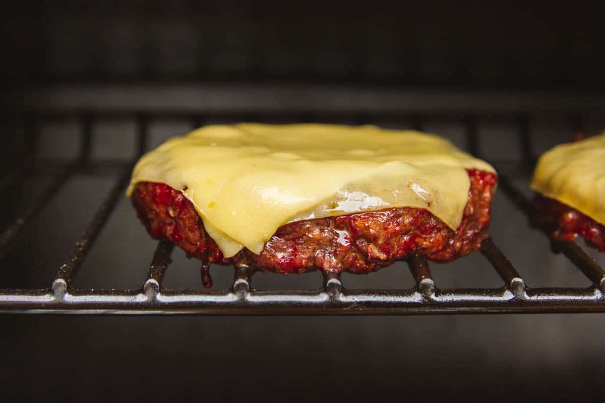 A close up of the smoked burger with cheese on top.