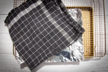 Covering the salmon with aluminum foil and a towel.