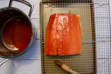 Glazing the cured salmon with the maple glaze.
