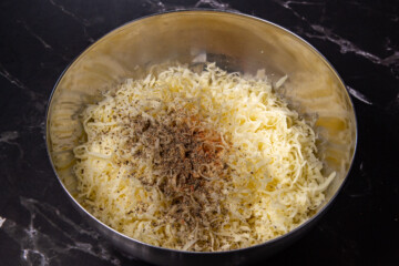 Smoked gouda, mozzarella, black pepper and bbq spice in a mixing bowl.