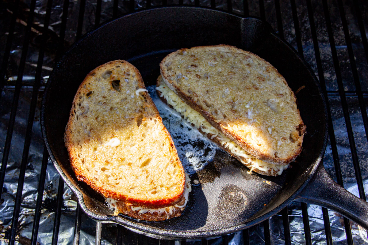 Cooking the grilled cheese in a pan with lots of butter.