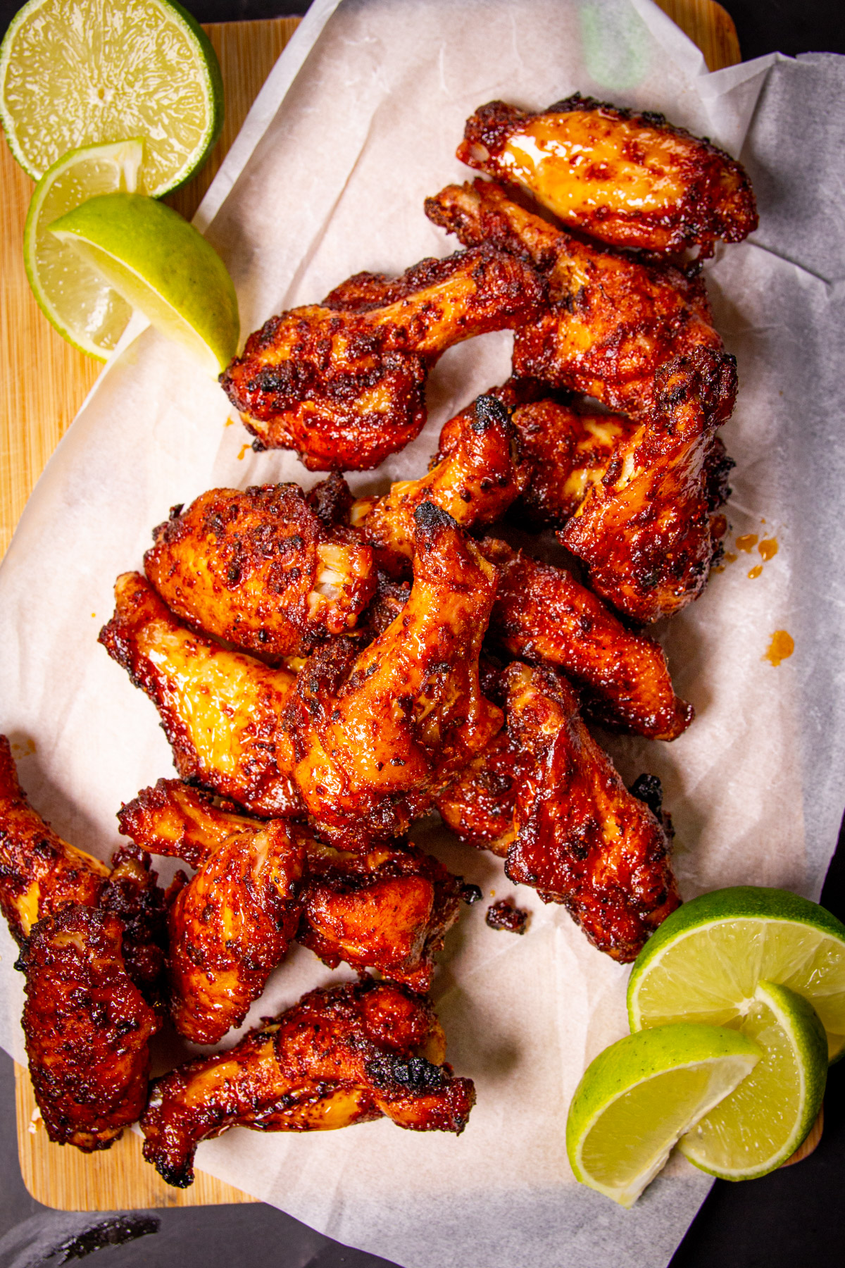 The finished wings on a board with lime wedges beside.