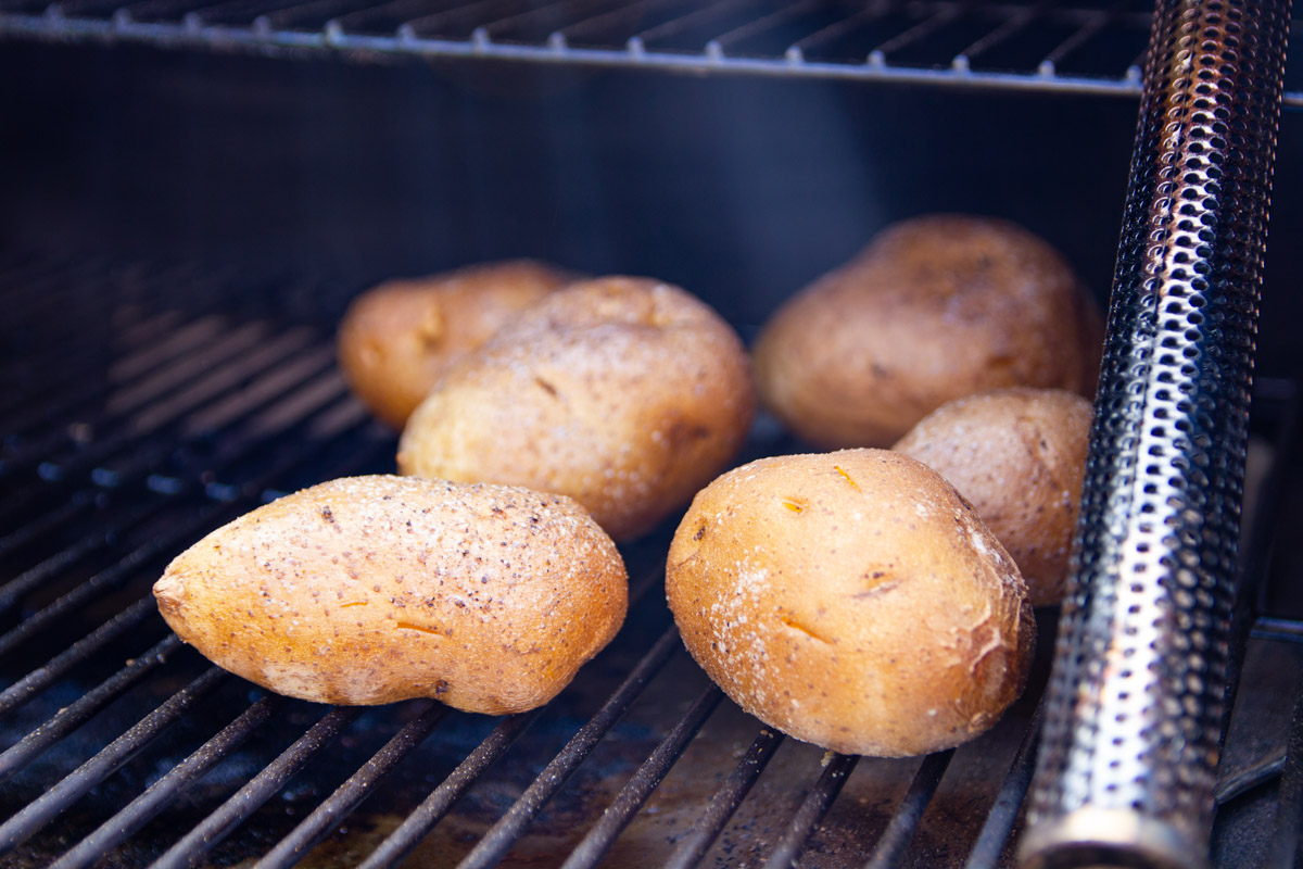 Spuds on the Traeger with a pellet tube in the background.