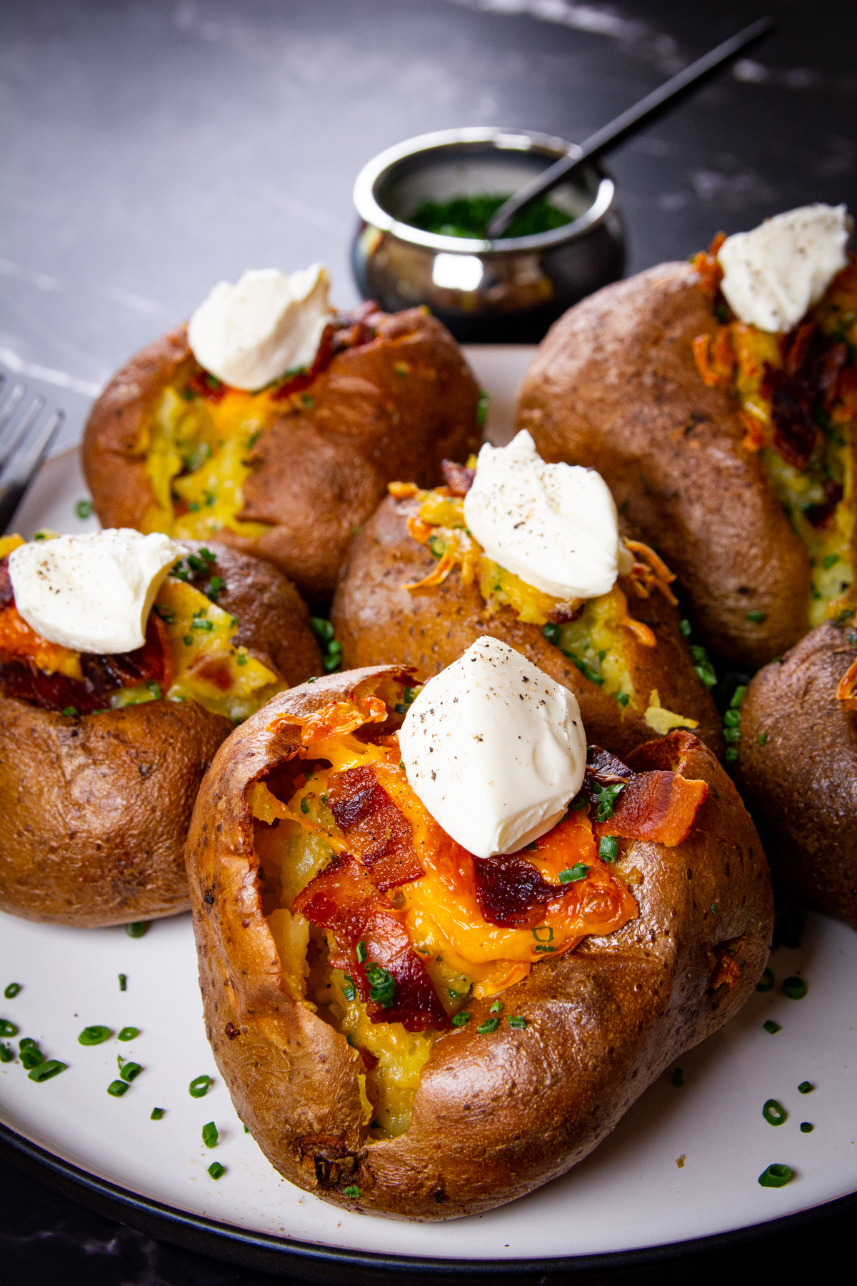 Twice baked spuds on a plate topped with creme fraiche.