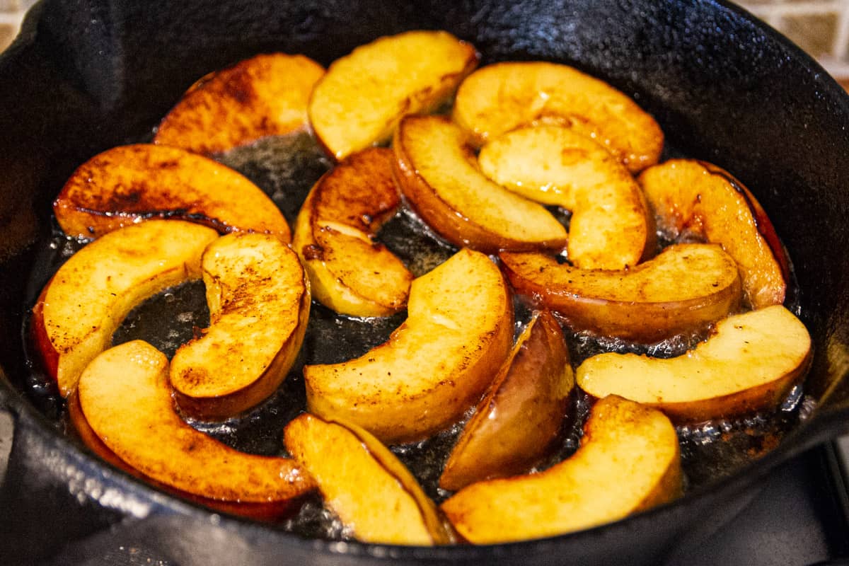 Frying the apples in butter and flipping them over.
