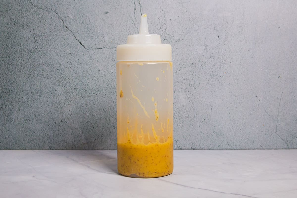 The mustard dressing in a squeeze bottle.